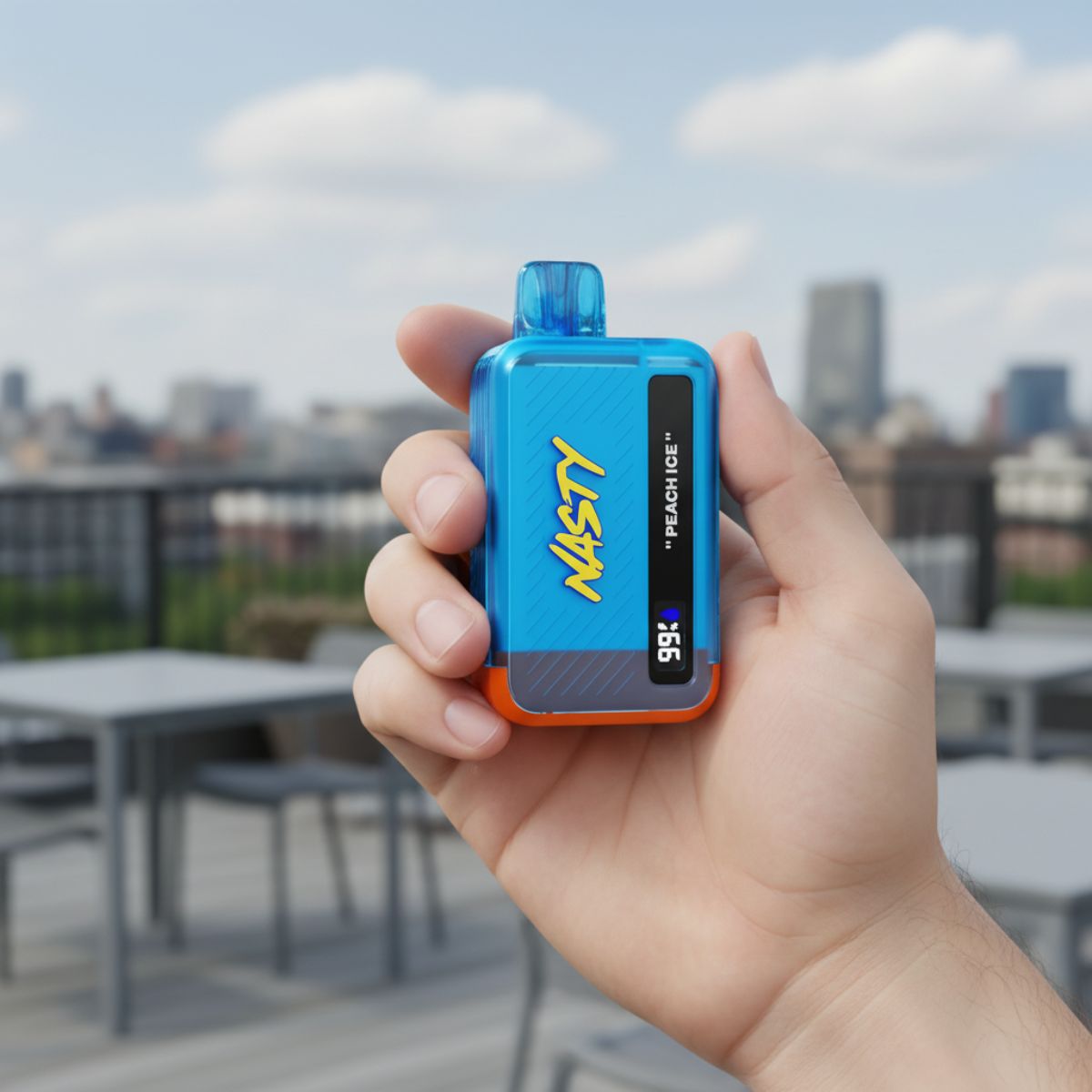 Person holding a Nasty Bar 9k Peach Ice disposable vape in their hand on a rooftop